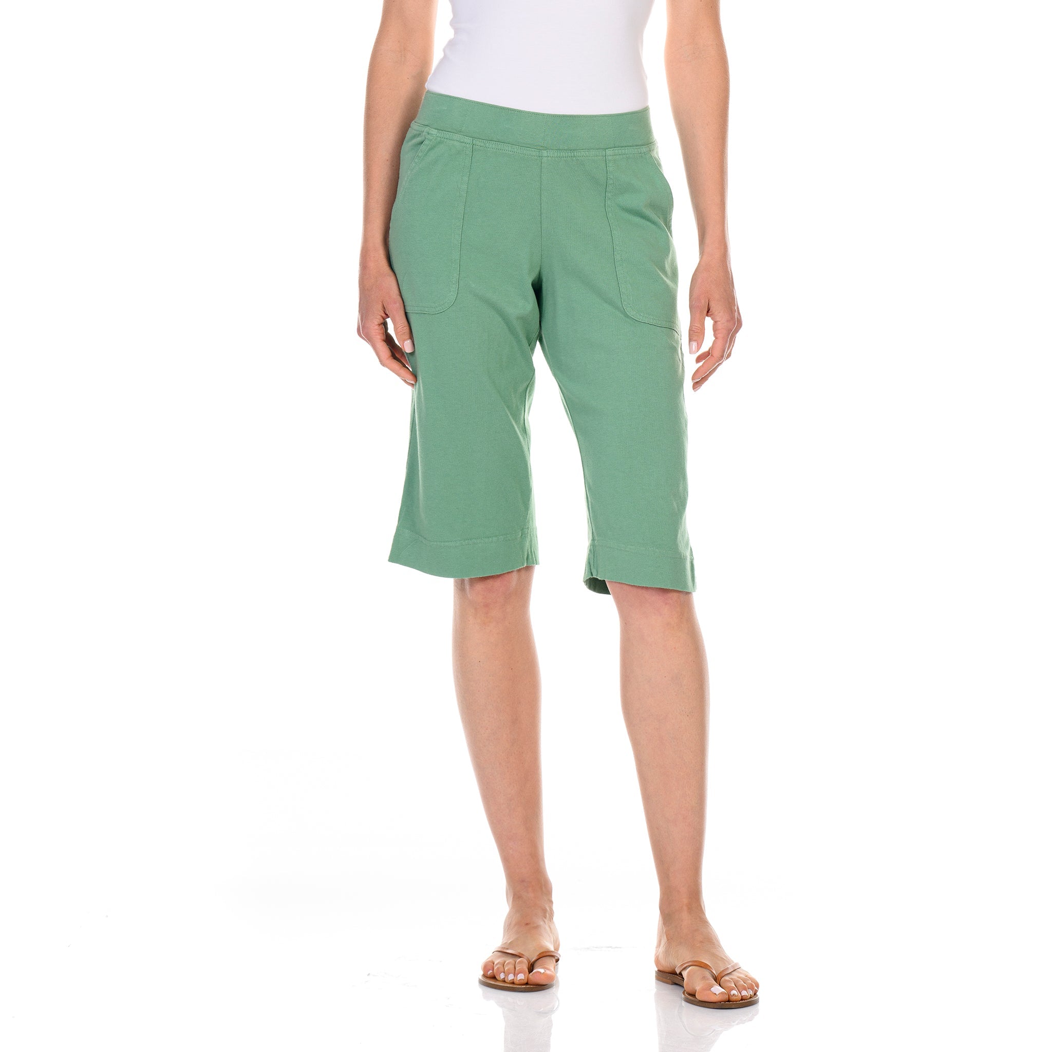 A person wearing a white cotton jersey sleeveless top, Fresh Produce Clothes Key Largo Pedal Pushers in Daffodil-Lagoon, and tan sandals stands against a white background.