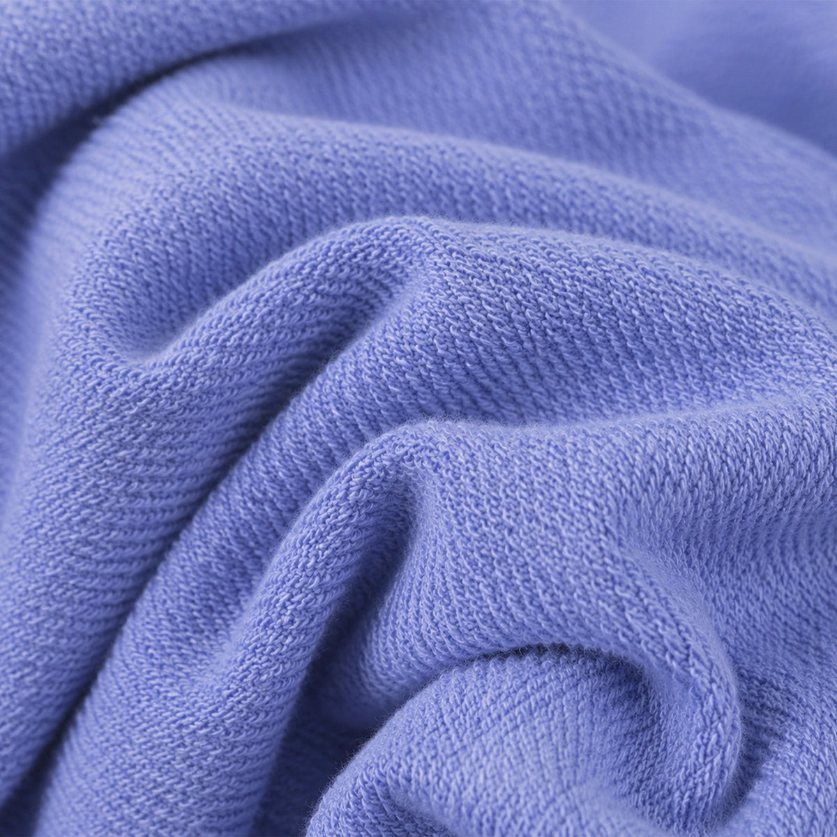 A close-up of the soft, light purple french terry fabric of Fresh Produce Clothes Coronado 7″ Key Largo Shorts, showcasing its textured, knitted surface with gentle folds and wrinkles.
