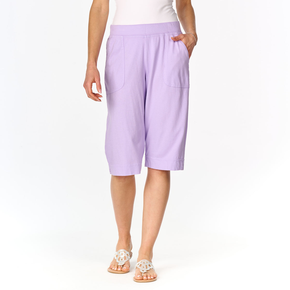 A person wearing the Fresh Produce Clothes Key Largo Pedal Pushers in a light purple shade, paired with a white top and white sandals, standing against a plain white background.