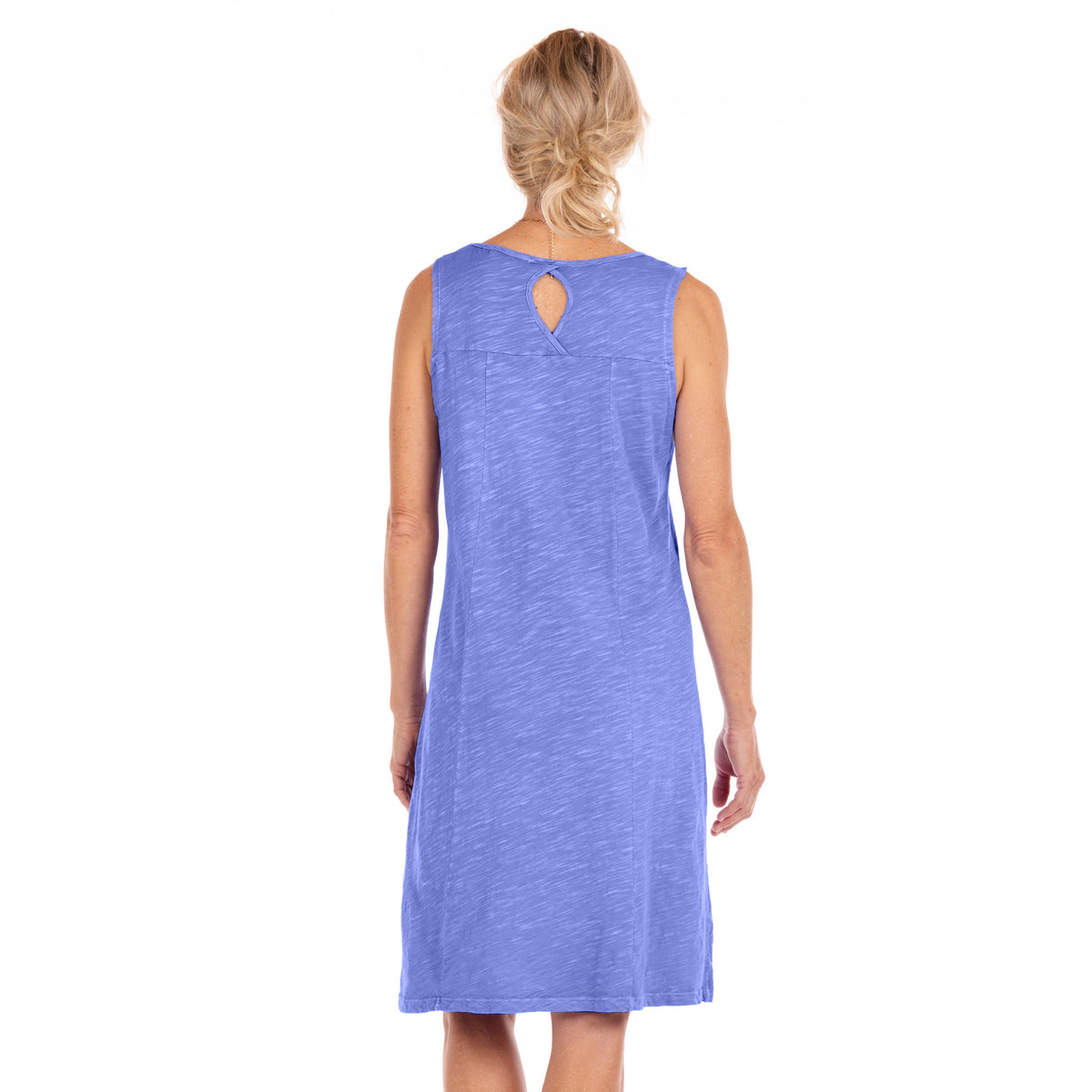 A woman with blonde hair in a loose bun is shown from the back, wearing the sleeveless, knee-length Marissa Dress by Fresh Produce Clothes in light blue, styled in an A-line silhouette against a plain white background.